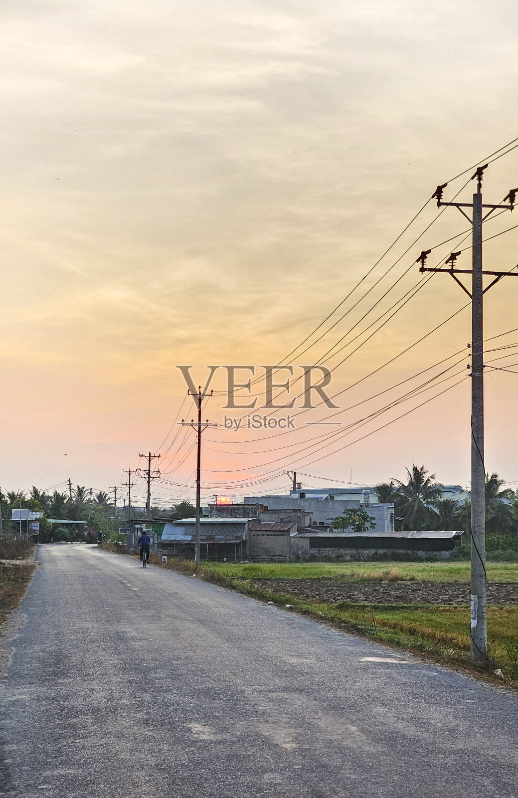 黎明时分，柏油路上挂着电线杆照片摄影图片