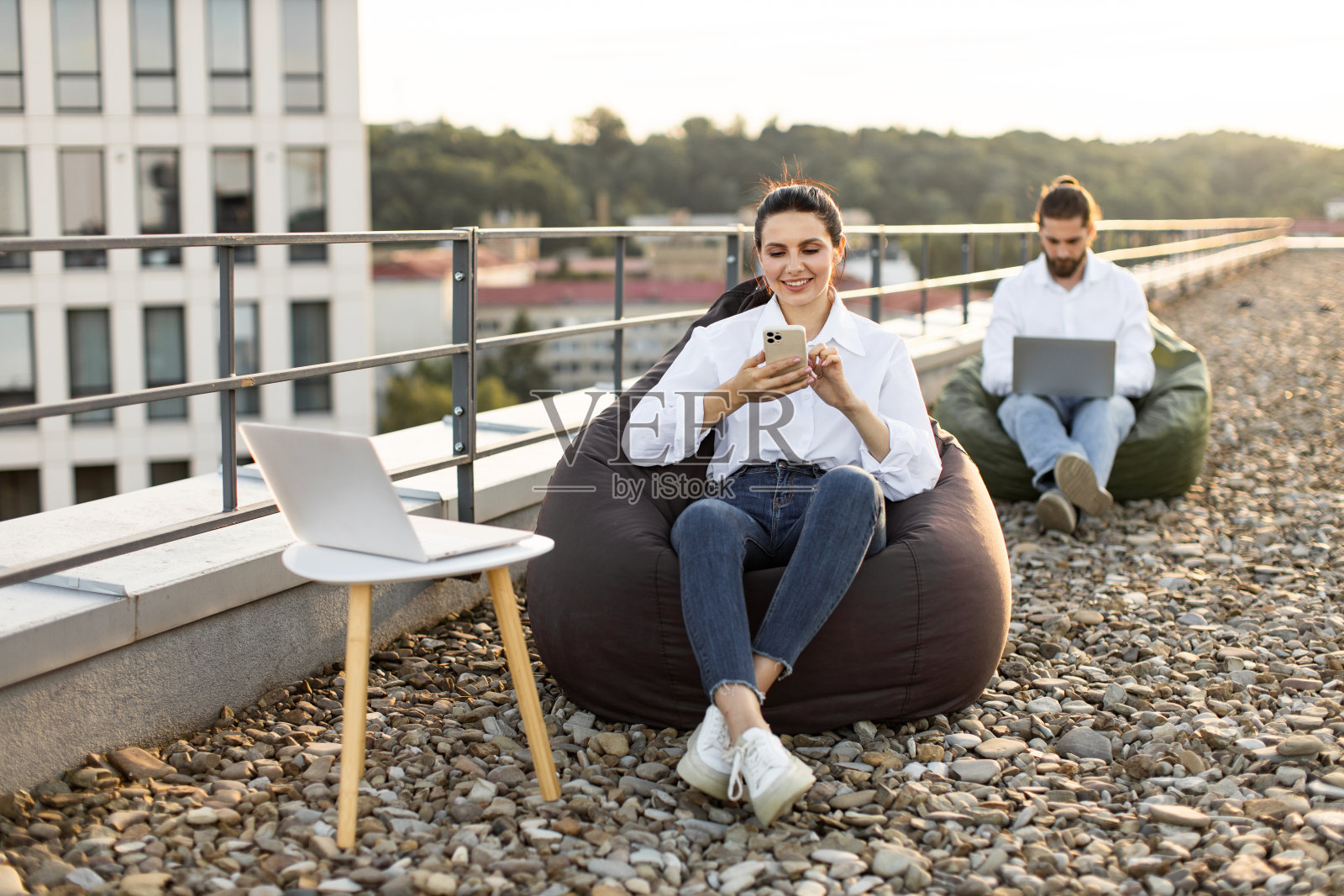 带着豆袋在屋顶上远程工作和放松照片摄影图片