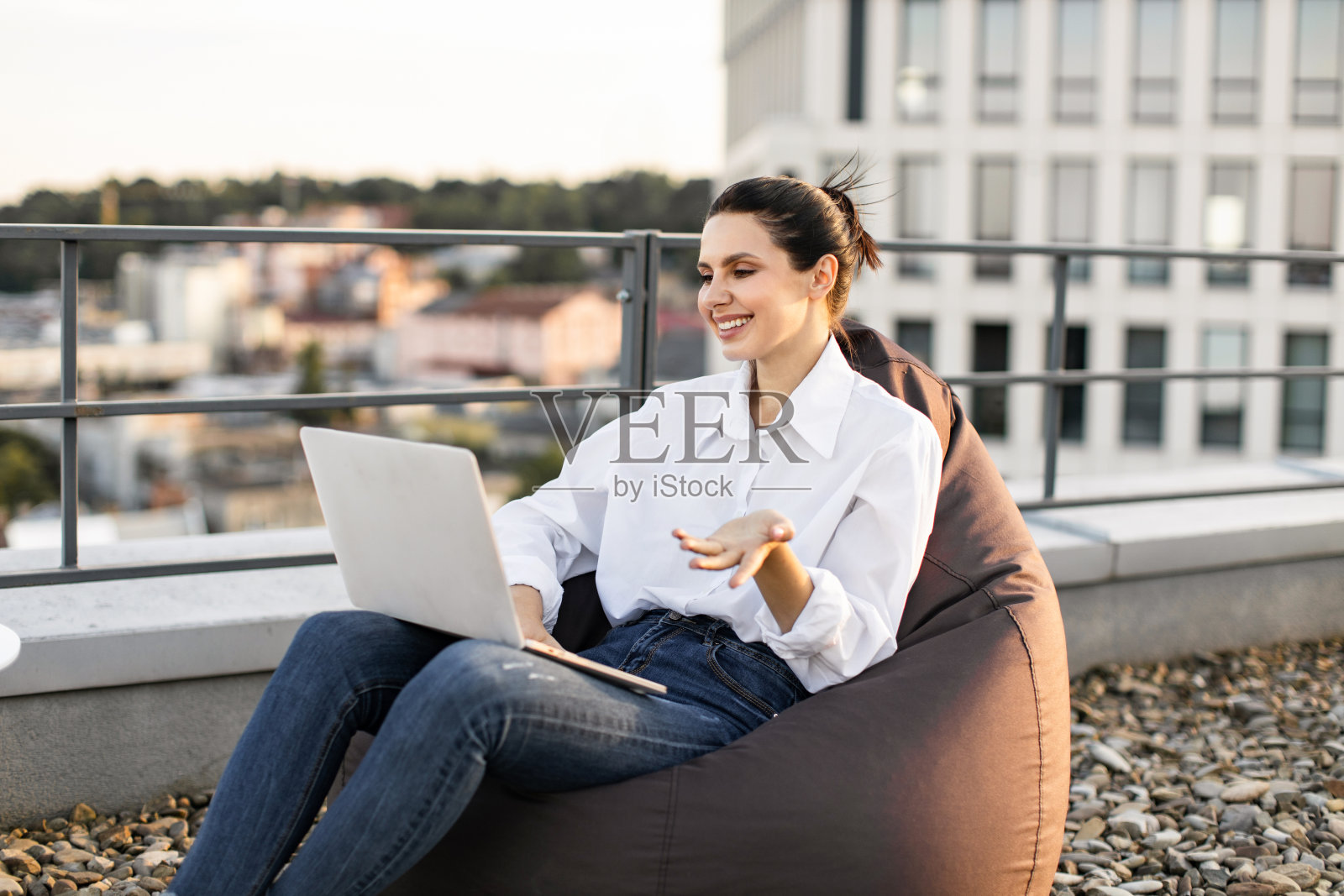 在屋顶露台上用笔记本电脑工作的女人照片摄影图片