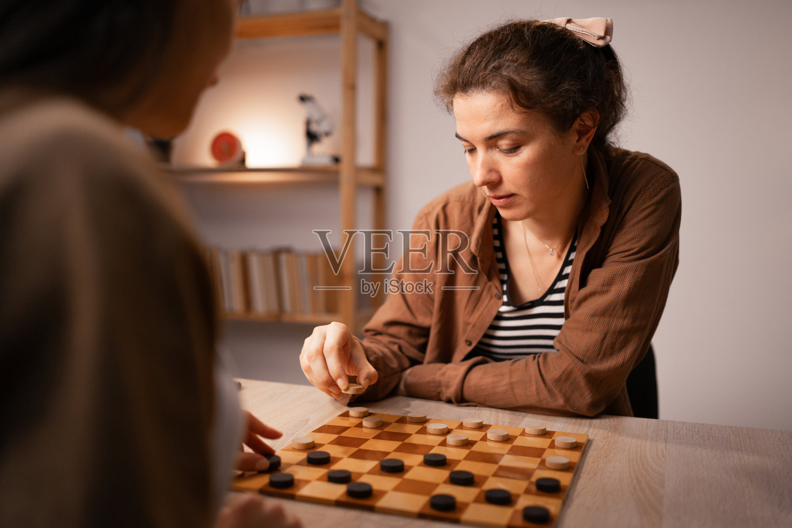 两名妇女在家玩跳棋，从事棋类游戏休闲活动照片摄影图片