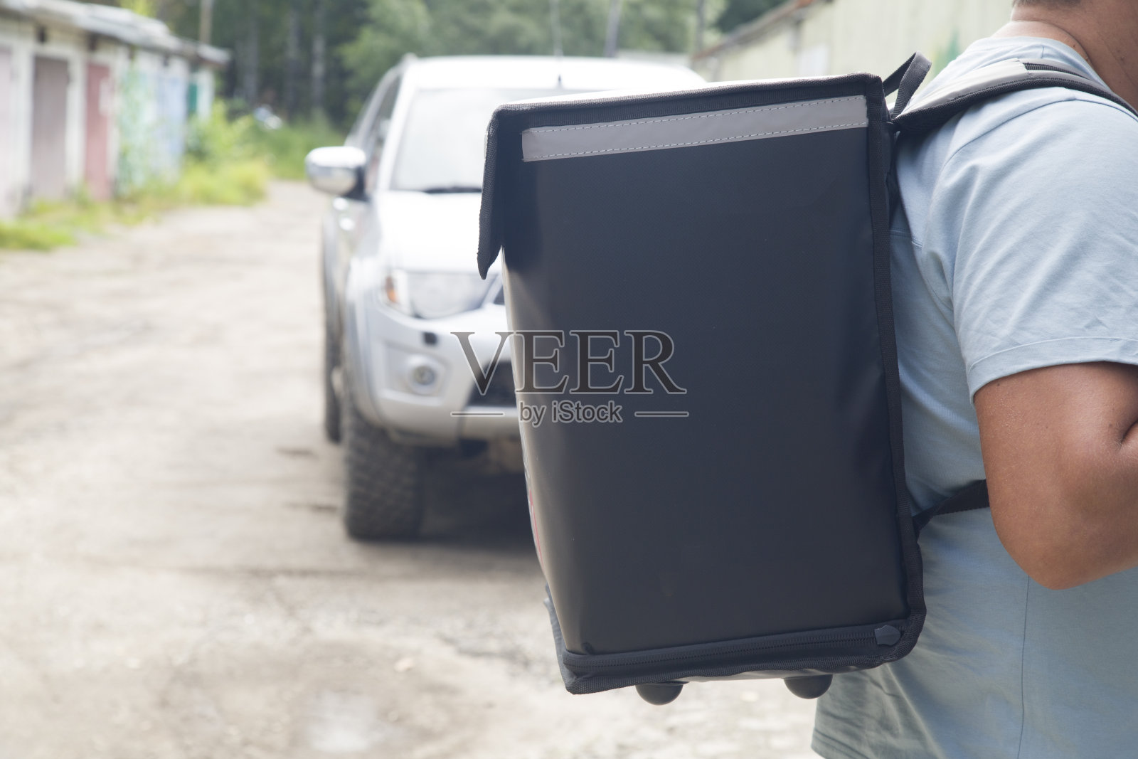 送餐上门。一个带着特殊背包的快递员。照片摄影图片