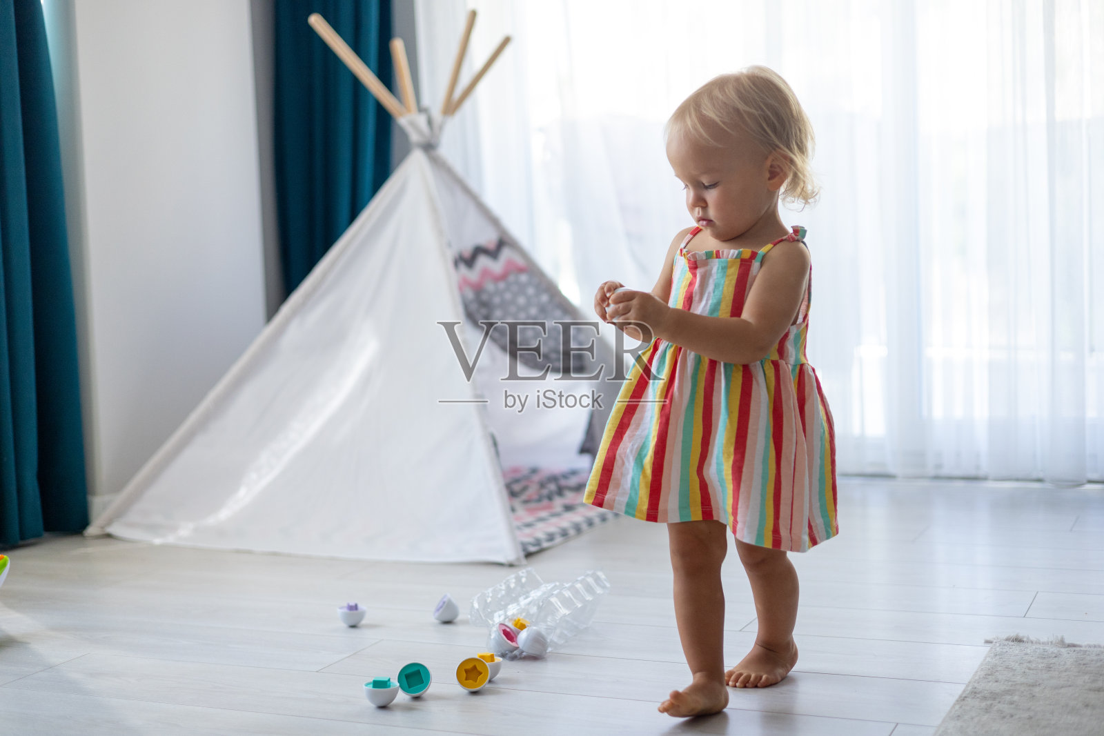 一个漂亮的金发小女孩在玩塑料蒙台梭利蛋照片摄影图片