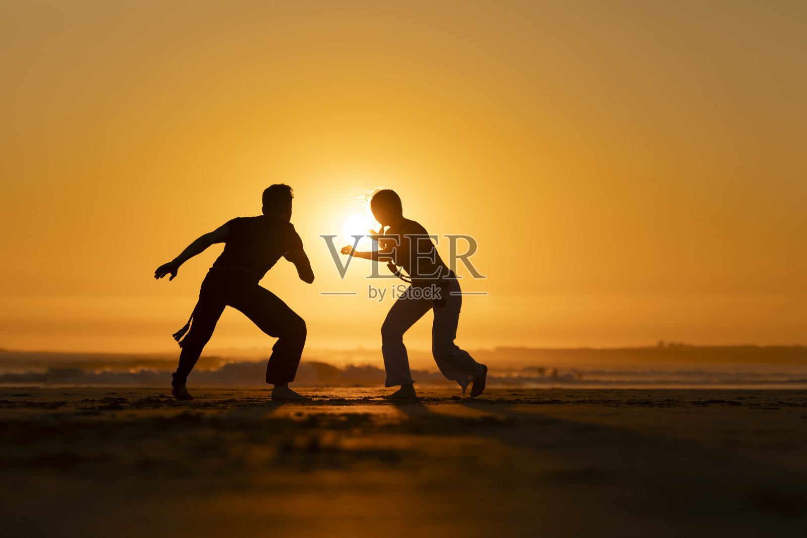 两个人在沙滩上玩空手道照片摄影图片