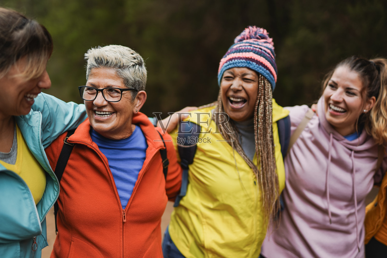 一群多代女性在山林徒步旅行中一起享受乐趣-多种族女性朋友在户外散步-运动和周末活动-关注年长的金发女子照片摄影图片