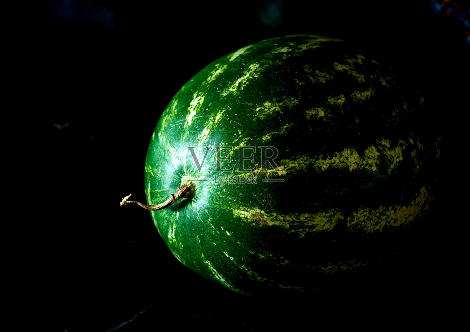 西瓜和甜瓜躺在黑色的背景上照片摄影图片