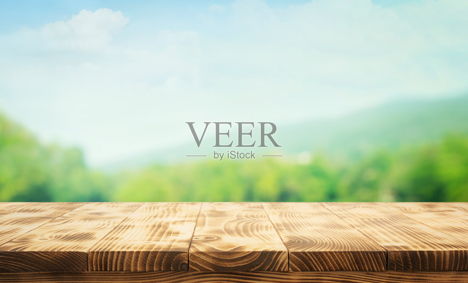 真实照片的复古木制顶部与模糊的山，和绿色的自然森林在蓝色的天空背景。照片摄影图片