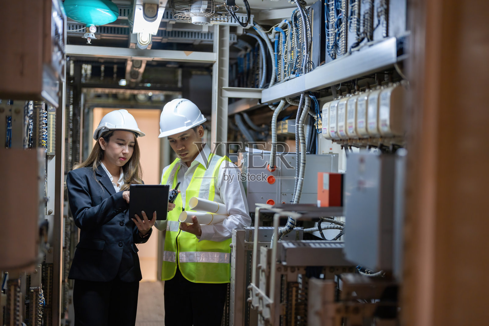 在电力行业，亚洲男性和女性工程师是必不可少的。他们的专业知识和奉献精神有助于保持高效运营并推动行业创新。照片摄影图片