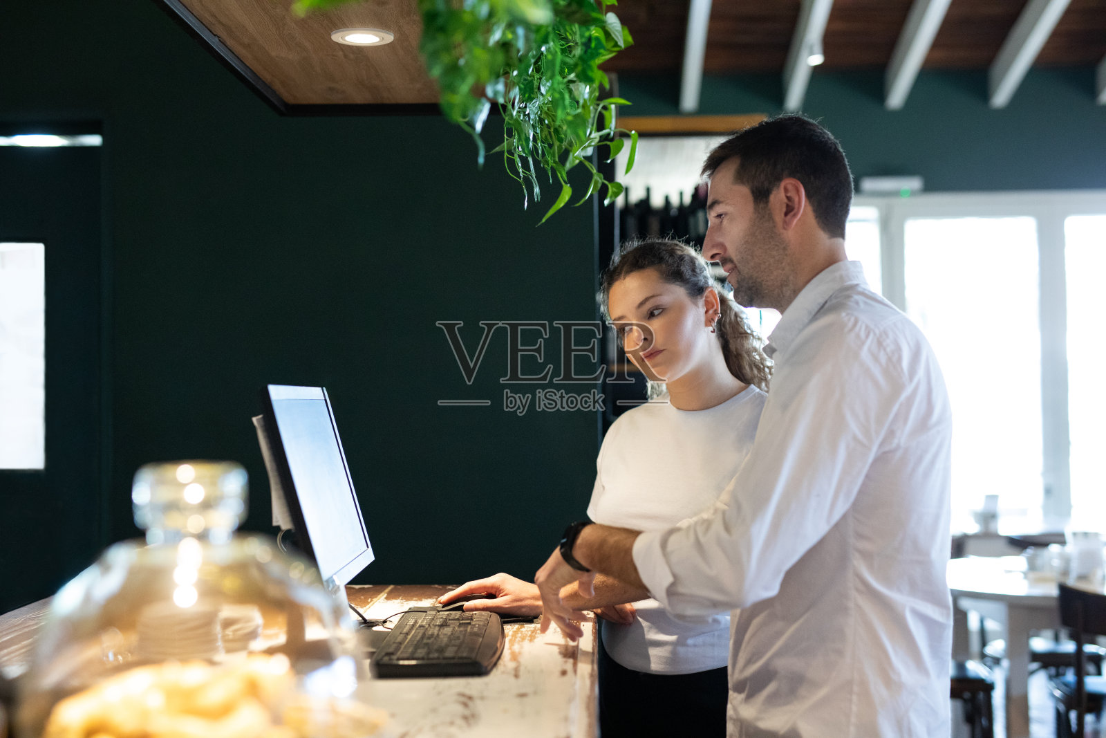 年轻女子第一天上班，在咖啡店学习照片摄影图片