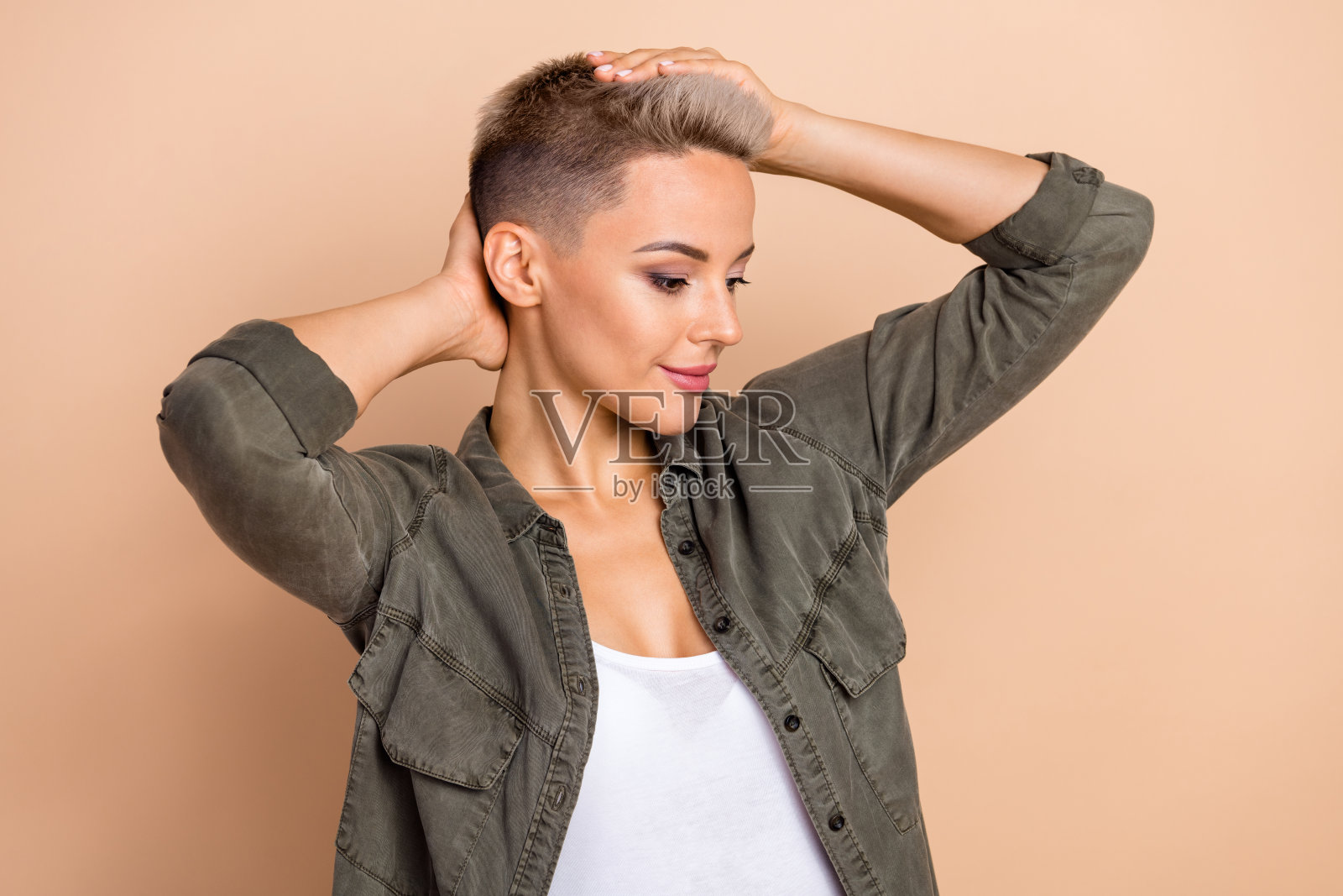 美丽满意的发型结果的照片金发短发的女人穿卡其时尚衬衫完美无瑕孤立在米色背景照片摄影图片