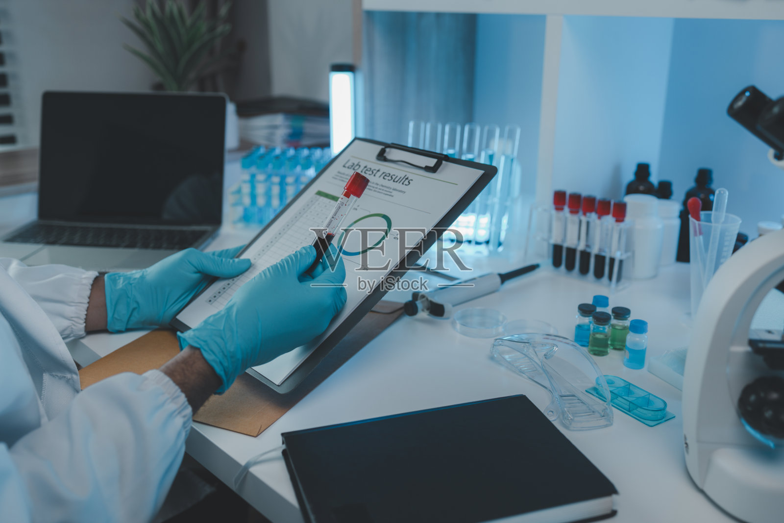 一位科学家正在审阅从参与化学测试的研究人员那里收到的实验结果和文件，化学家则集中精力阅读测试结果文件照片摄影图片