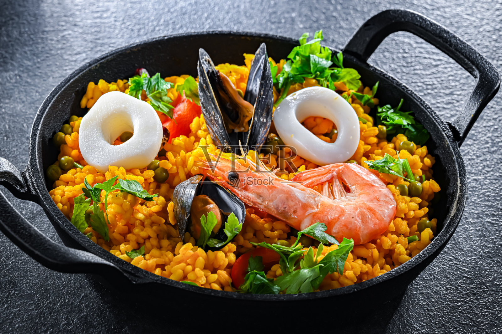 用铸铁平底锅盛海鲜海鲜饭照片摄影图片
