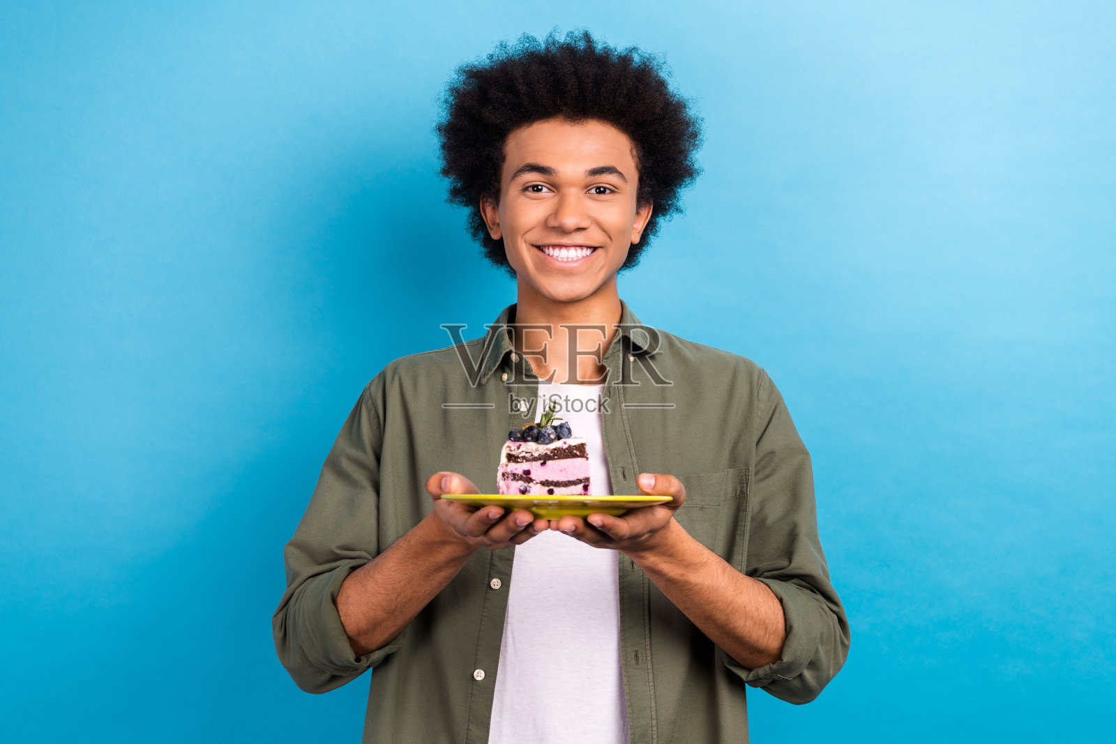 肖像满意的积极的家伙烫发穿卡其布衬衫持有板与巧克力蛋糕孤立的蓝色背景照片摄影图片