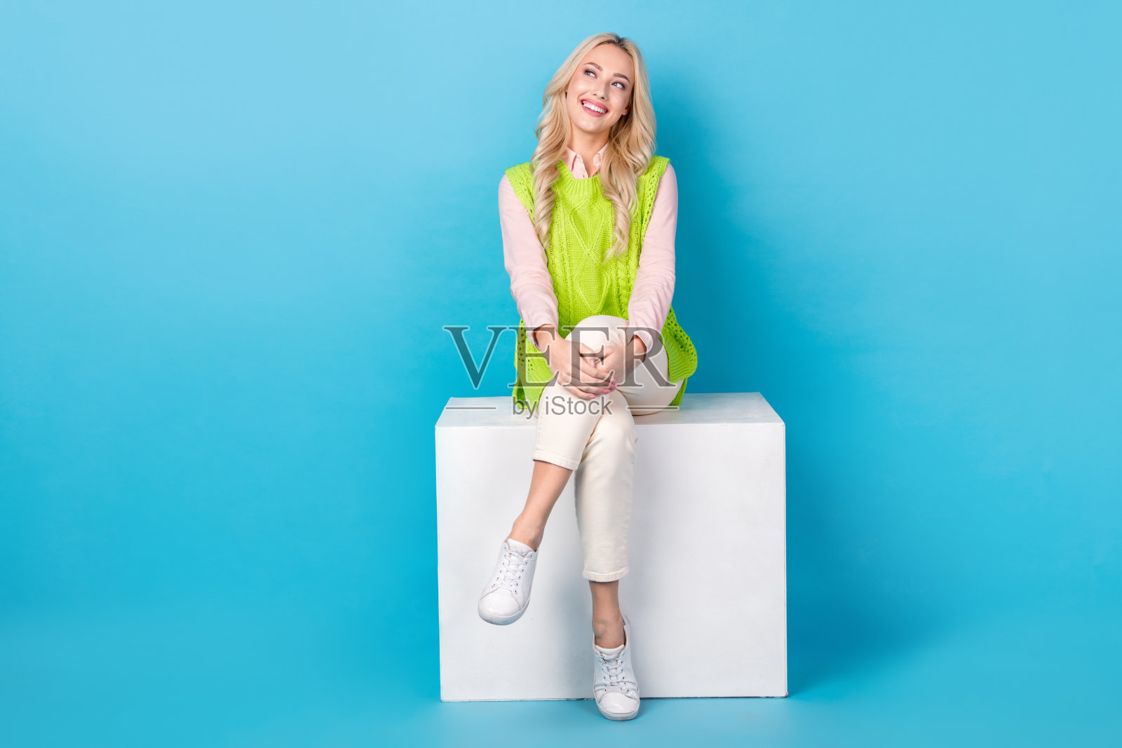 华丽的正面女士的全身照片坐在讲台上看起来空的空间孤立的蓝色背景照片摄影图片