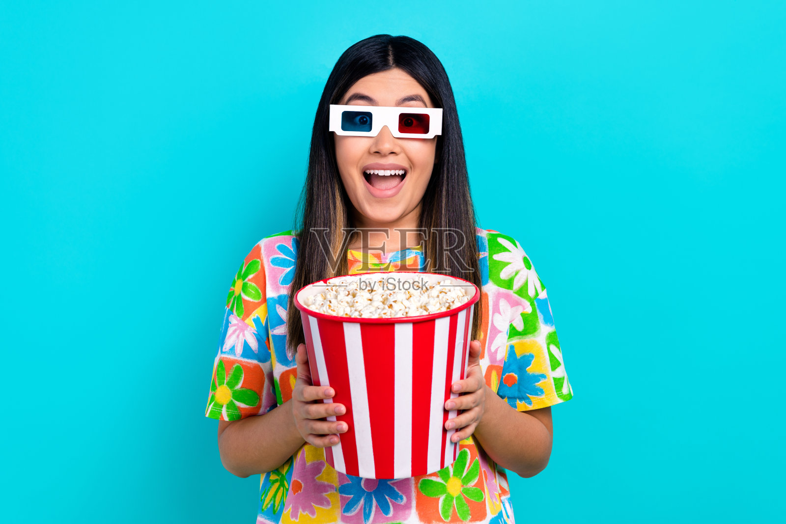 印象深刻的时髦女人穿着印花t恤令人兴奋地观看vr电影孤立的蓝色背景照片摄影图片