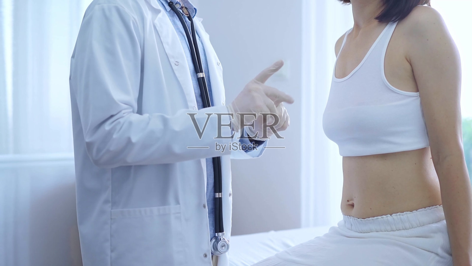 医生和病人。戴着白色医用手套的医生准备在诊所检查女病人。骨科与医学照片摄影图片