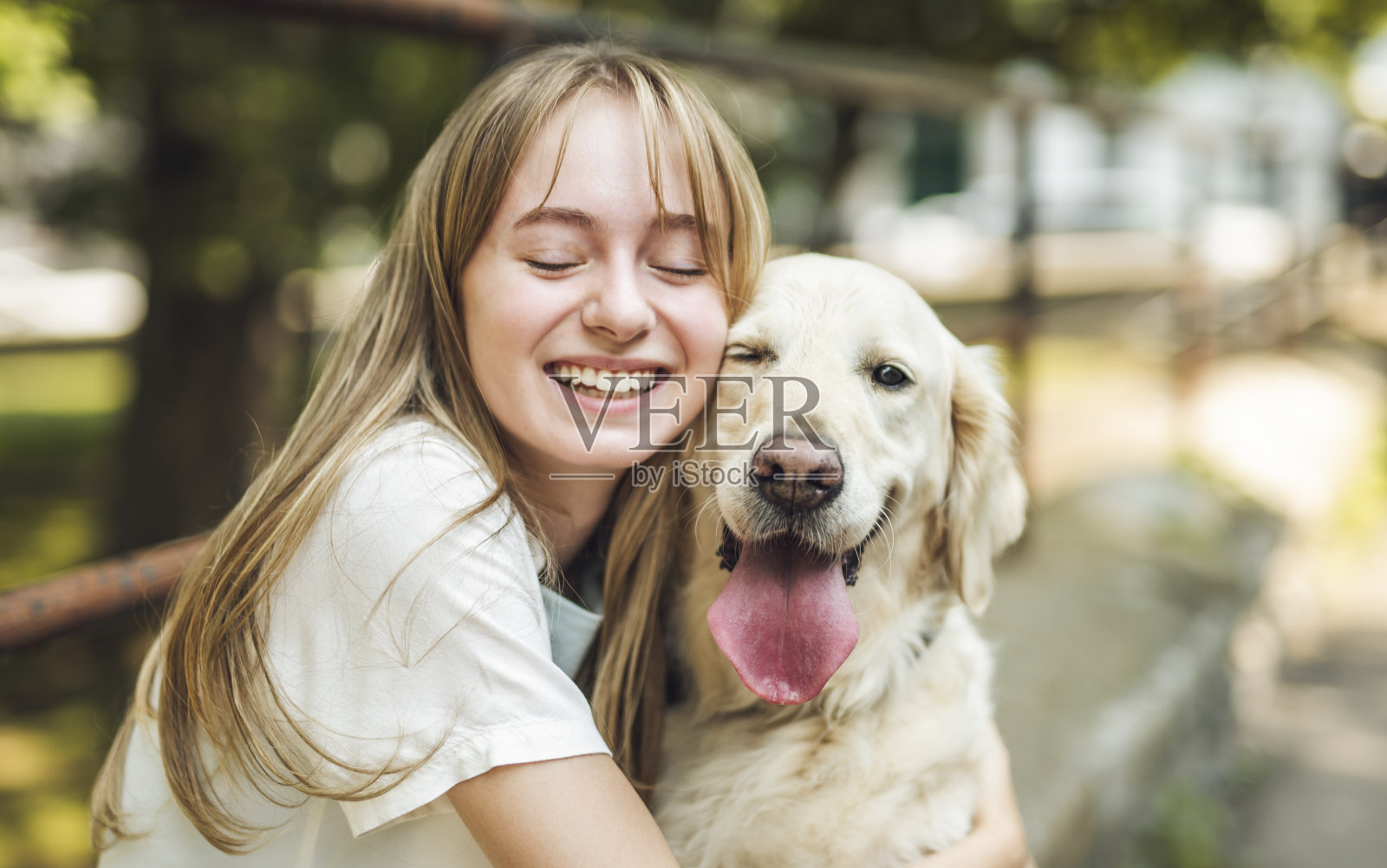 十几岁的女孩和金毛猎犬在外面玩耍的照片照片摄影图片
