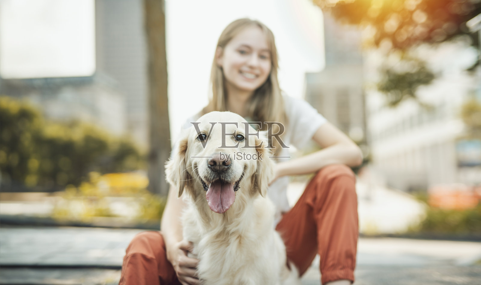 十几岁的女孩和金毛猎犬在外面玩耍的照片照片摄影图片