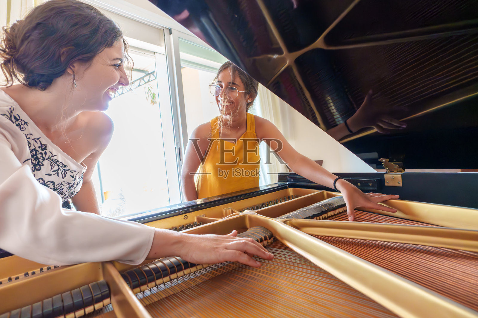 钢琴老师教十几岁的女学生三角钢琴的内部工作原理照片摄影图片