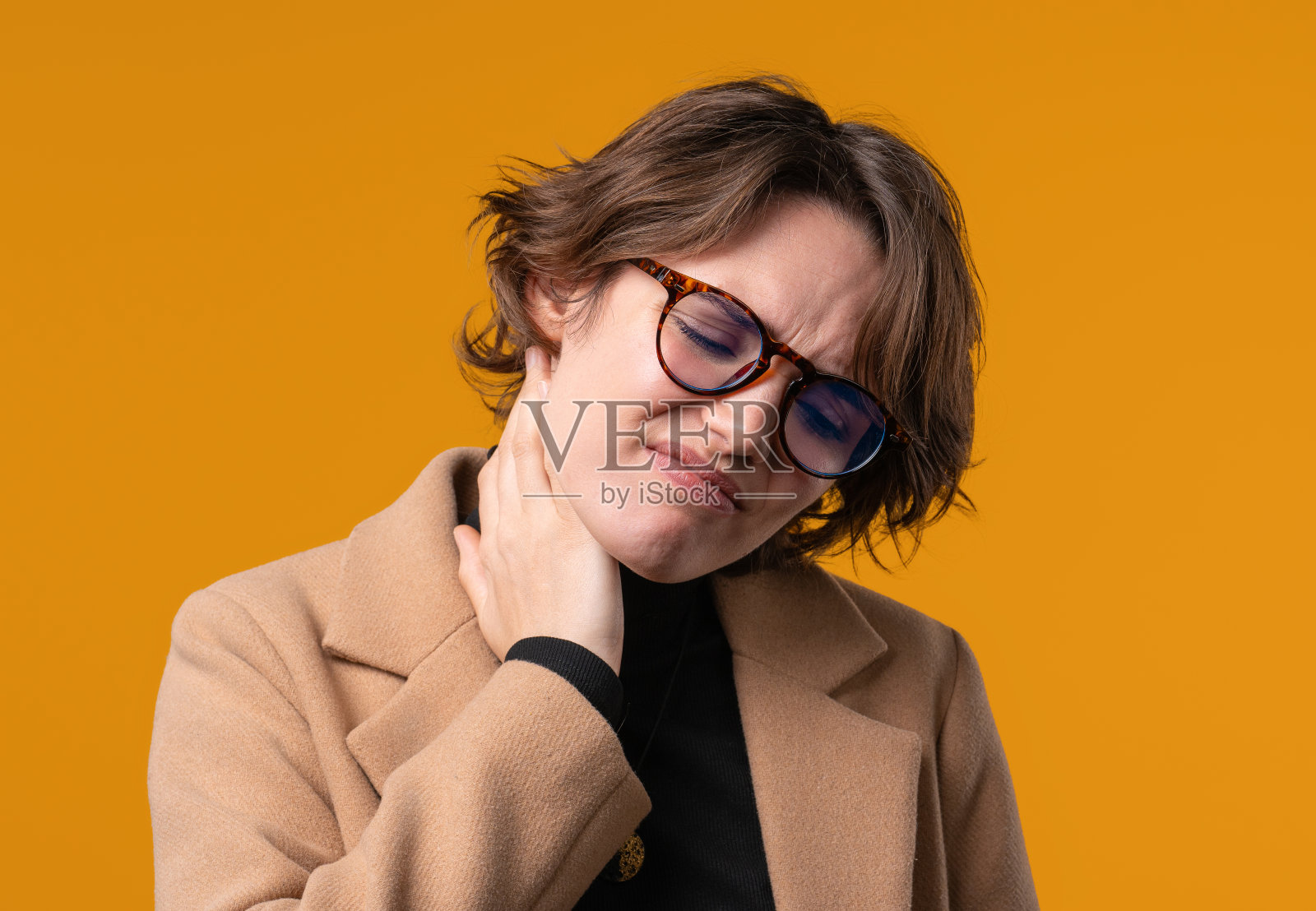 疲倦的年轻女商人感到颈部关节疼痛，按摩肌肉，揉头。因关节炎而感到不适的女士。医疗保健，医疗理念照片摄影图片