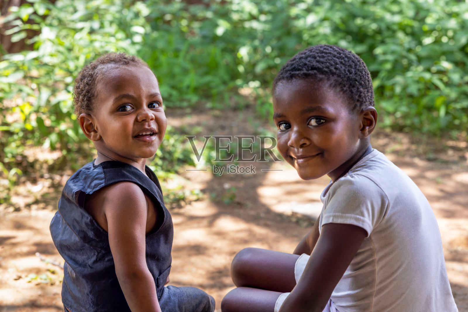 非洲男孩和女孩兄弟姐妹的肖像，卷曲的头发，在后院的花园里玩耍照片摄影图片