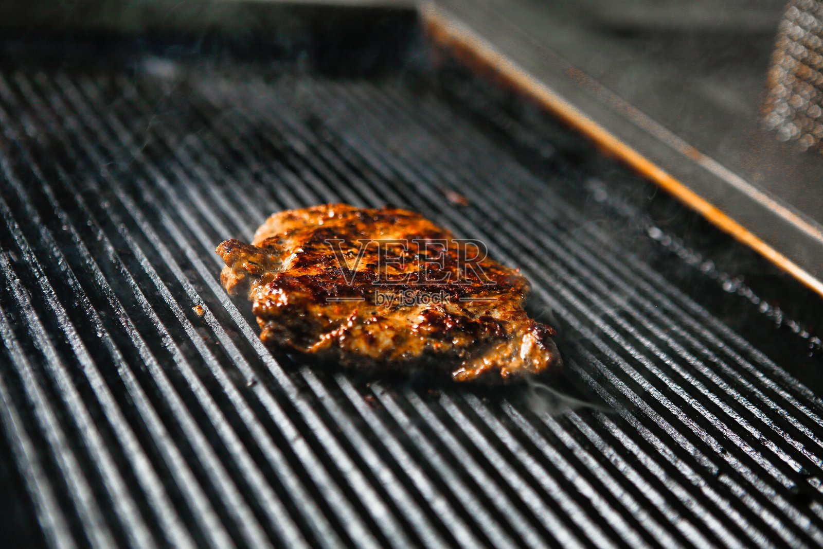 在平顶烤架上烤牛排照片摄影图片