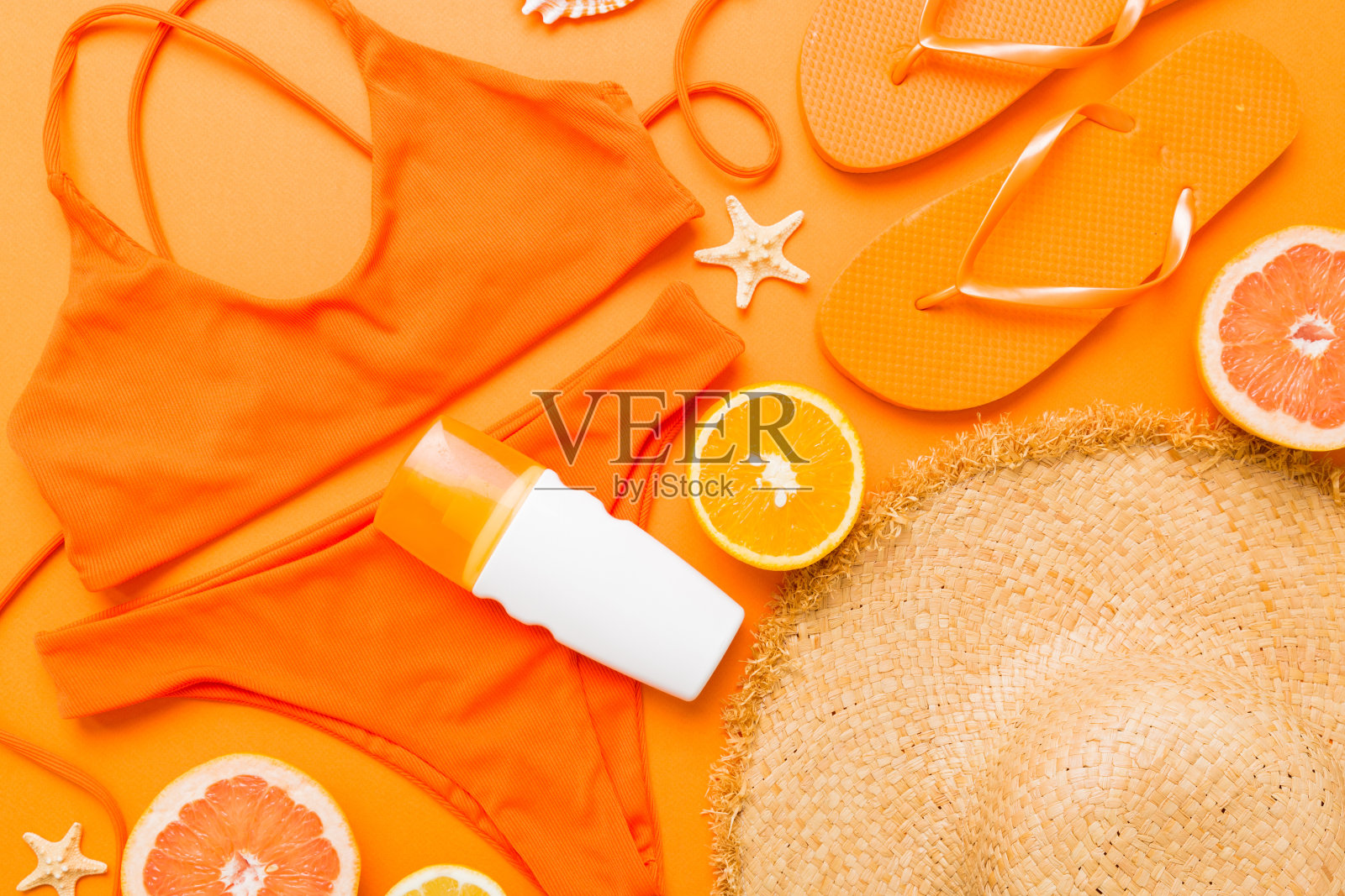 泳池配件概念。桌子上海滩物品的俯视图，明亮的比基尼，草帽和防晒护肤霜。五颜六色的沙滩装。平铺，复制空间照片摄影图片