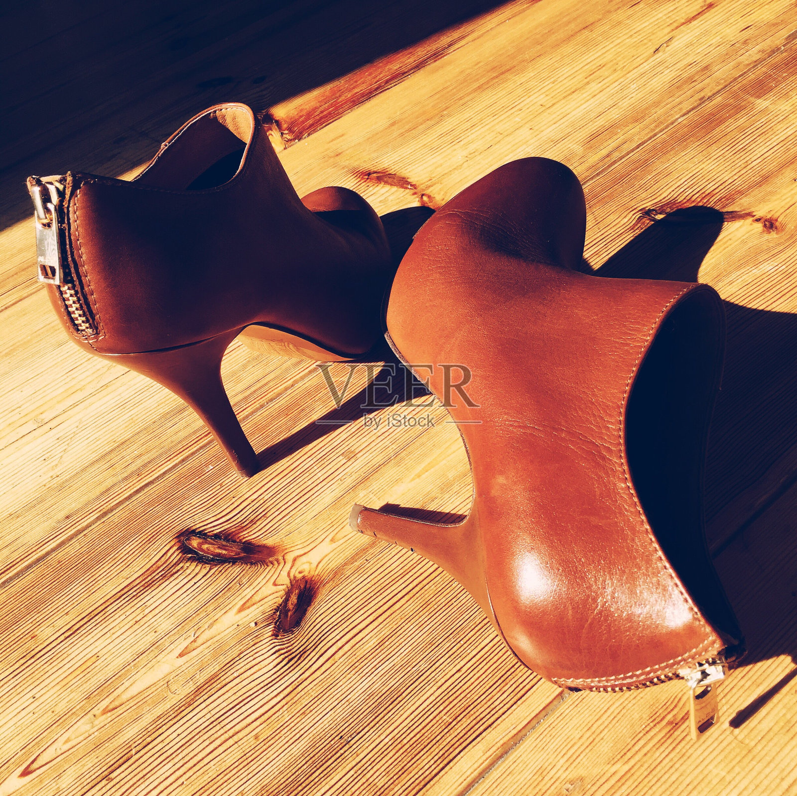皮革高跟鞋脚踝靴在硬木地板上的特写照片摄影图片