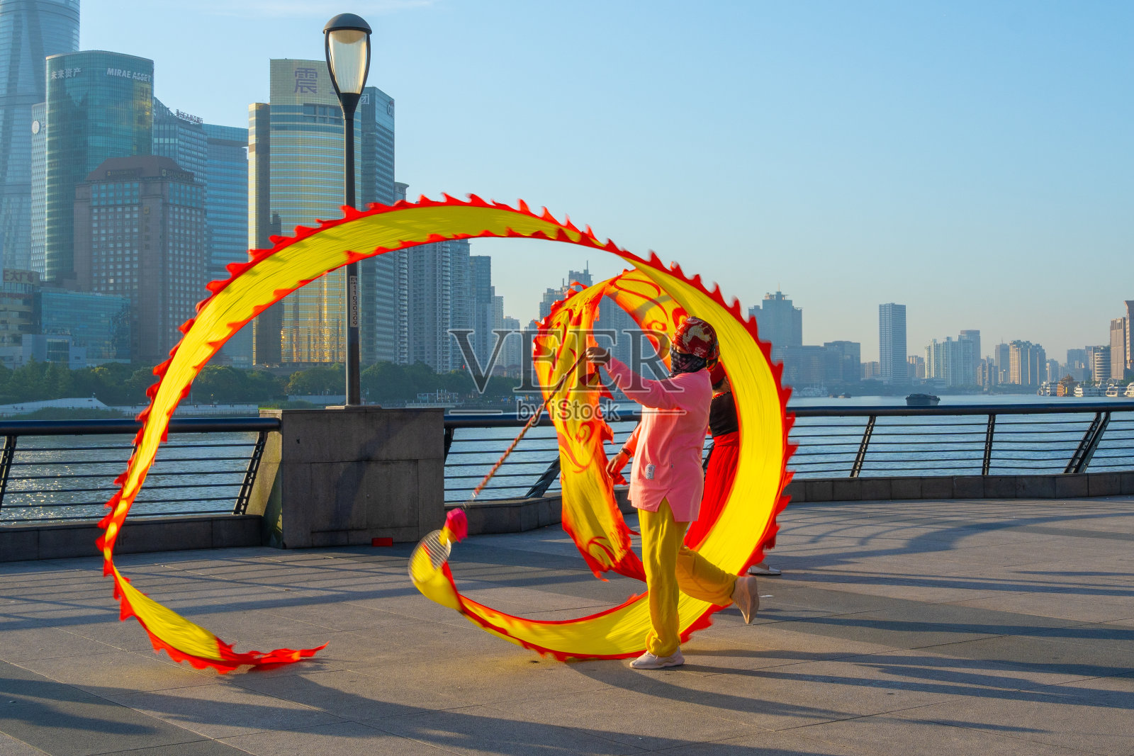 上午,在中国上海外滩,人们正在练习彩带舞龙。照片摄影图片