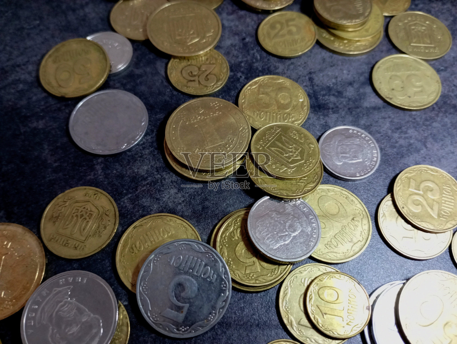 散落在黑暗纹理表面的乌克兰硬币。硬币的纹理和背景。关于金钱和财务的话题。照片摄影图片