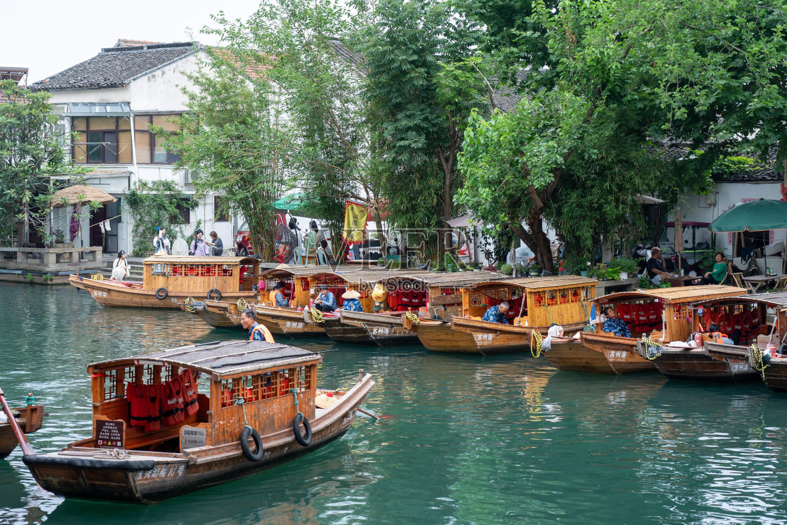 木船排列在中国苏州的运河上。照片摄影图片