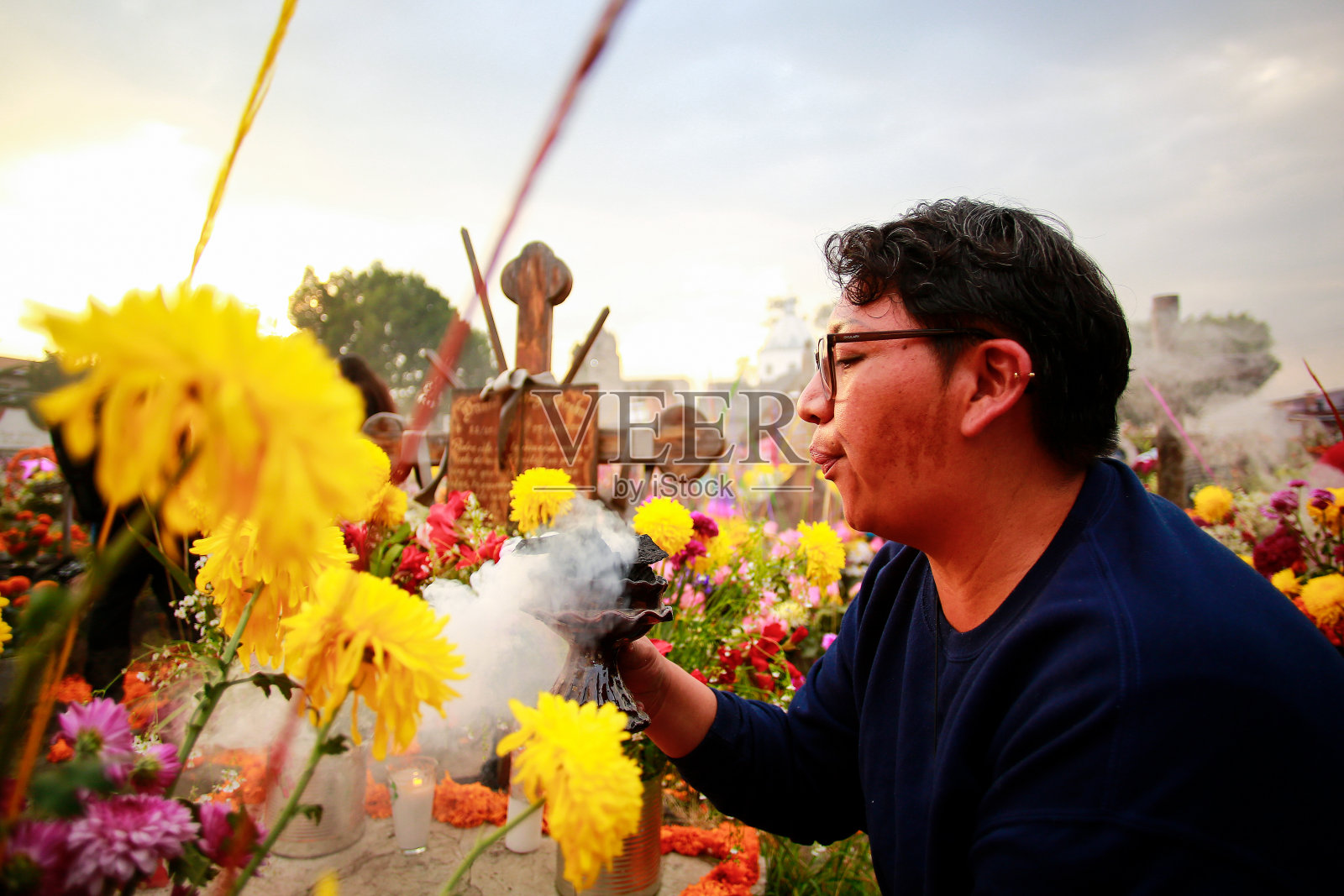 一名妇女在米克斯克的亡灵节点燃了香照片摄影图片