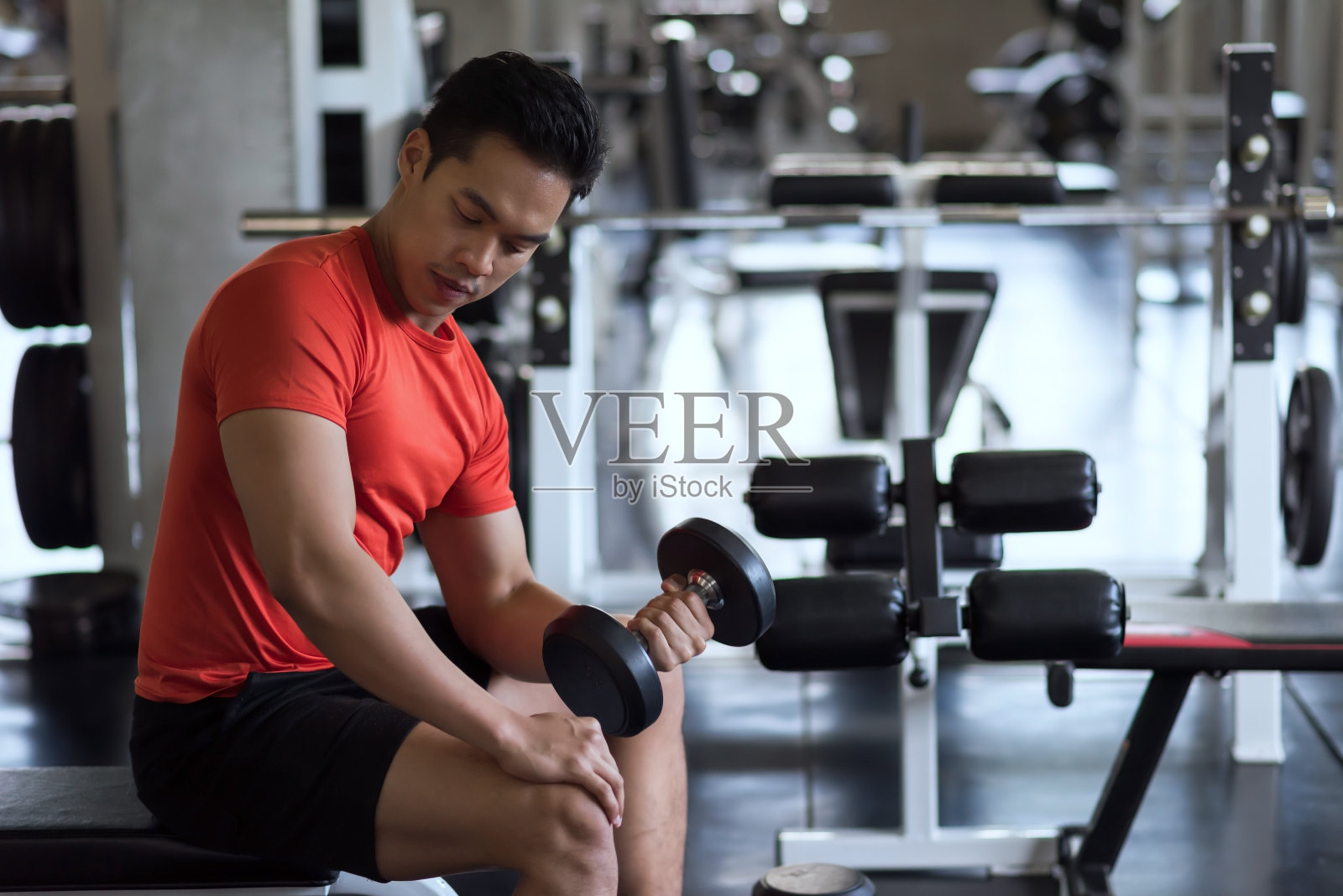 亚洲健美男子在健身房用左手举哑铃照片摄影图片