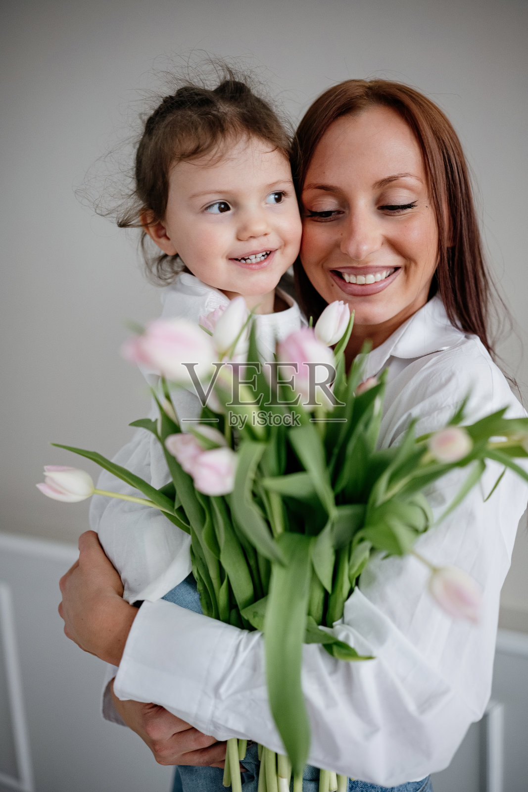 快乐的年轻妈妈抱着她可爱的女儿照片摄影图片