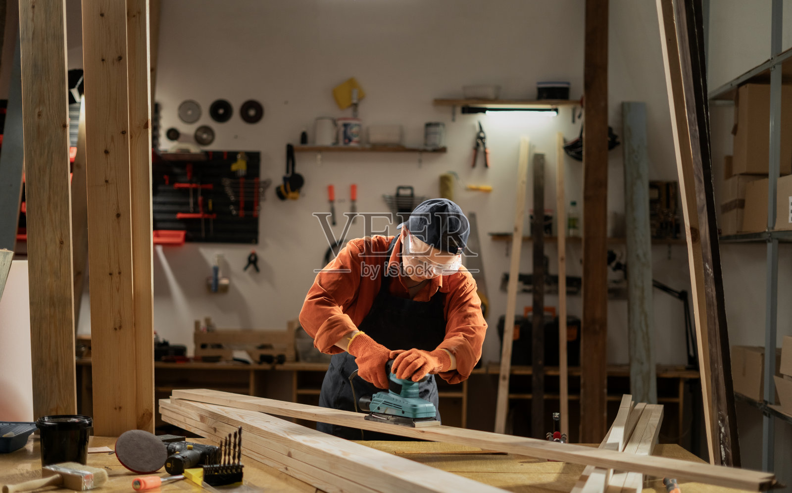 女木匠在车间用砂光机打磨木板照片摄影图片