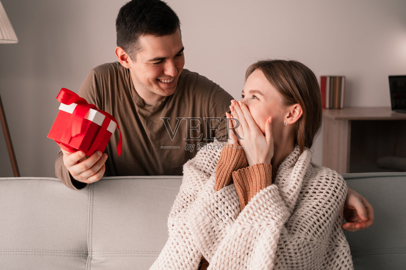 祝贺你和情人节的概念。男人拿着礼盒，拥抱并祝贺他的女人度假的肖像。幸福的一对。照片摄影图片