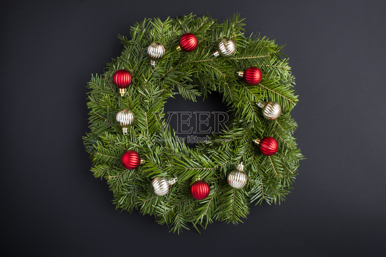 圣诞花环与红色和金色的珠子在黑色的背景。前视图。特写镜头。照片摄影图片