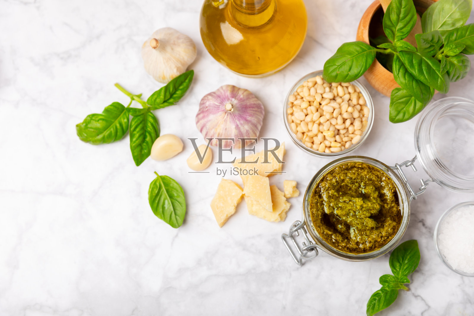 香蒜沙司。意大利罗勒香蒜沙司在纹理木背景。香蒜沙司的原料:新鲜罗勒，松子，帕尔马干酪和橄榄油。文本空间。副本的空间。照片摄影图片