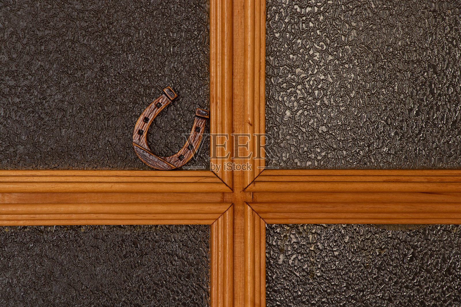 一个小木马蹄铁立在一间公寓的玻璃门上照片摄影图片