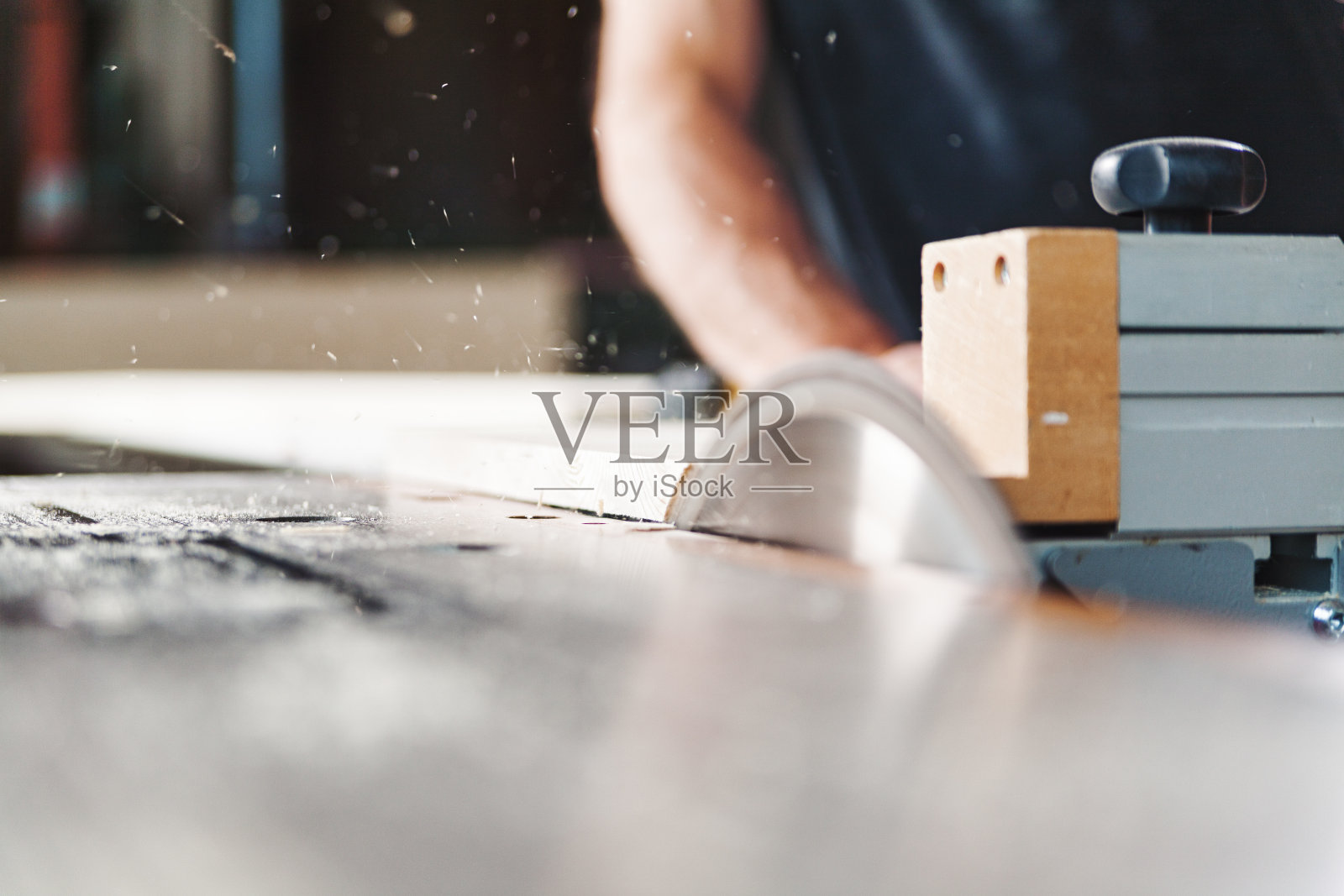 木匠用台锯切割木头，产生锯末照片摄影图片