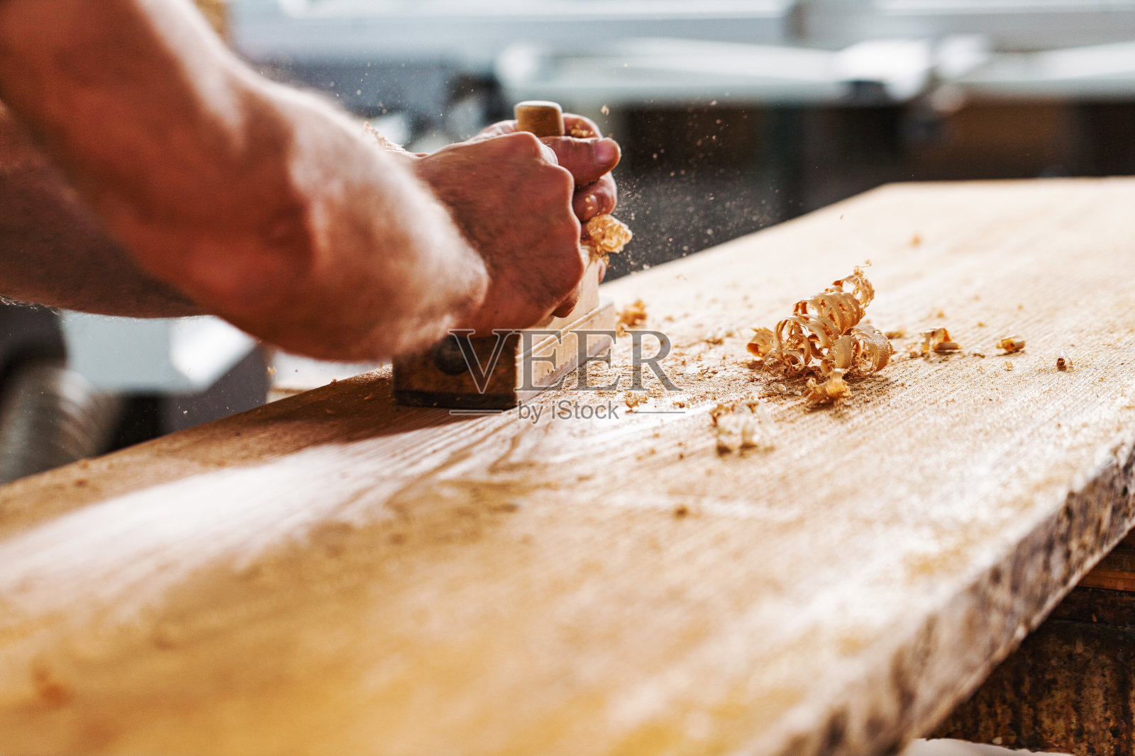 木匠在车间用手刨木板照片摄影图片