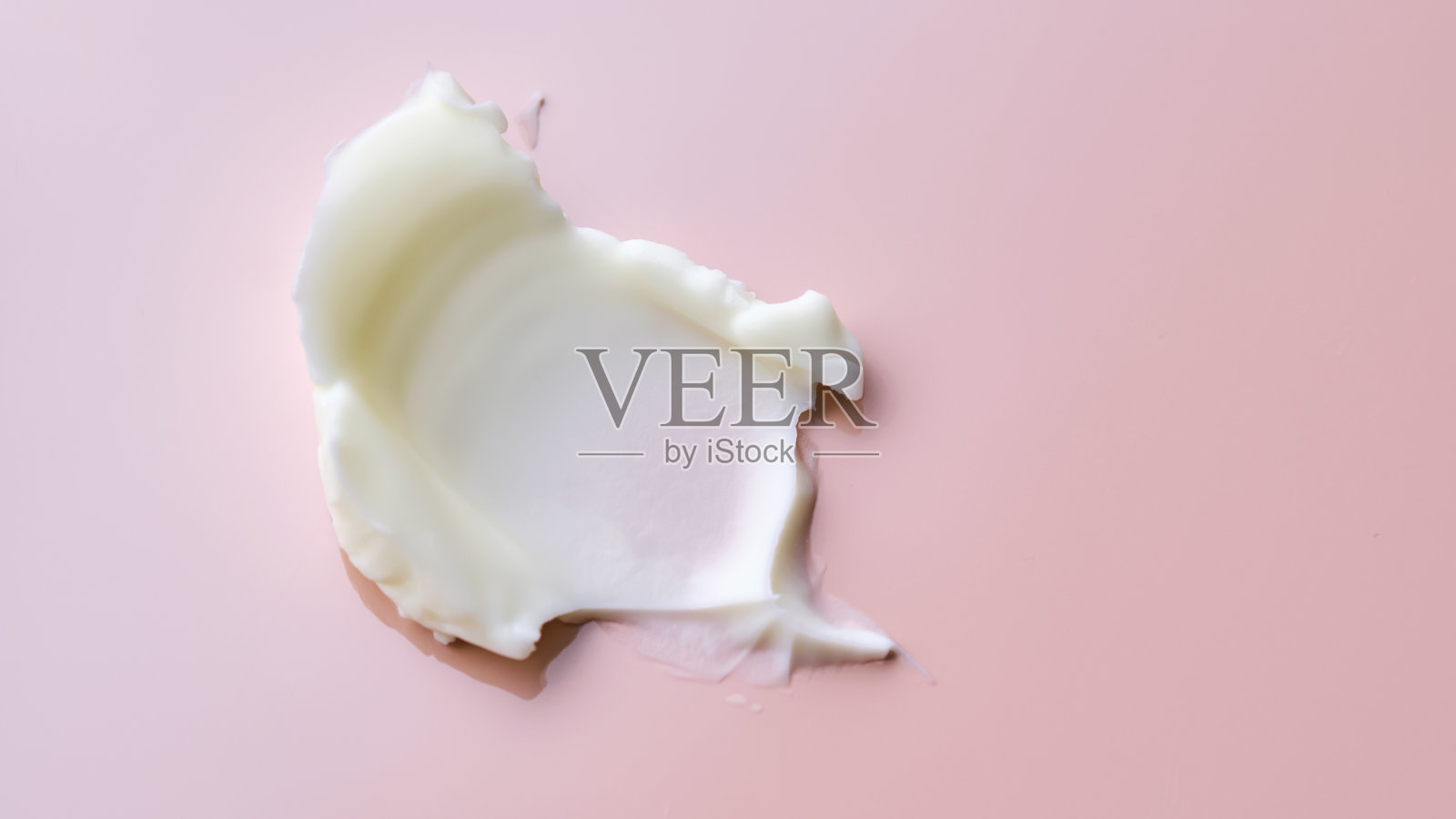 化妆品黄油在粉红色背景上的纹理。呈现出浓郁而滋养的口感。照片摄影图片