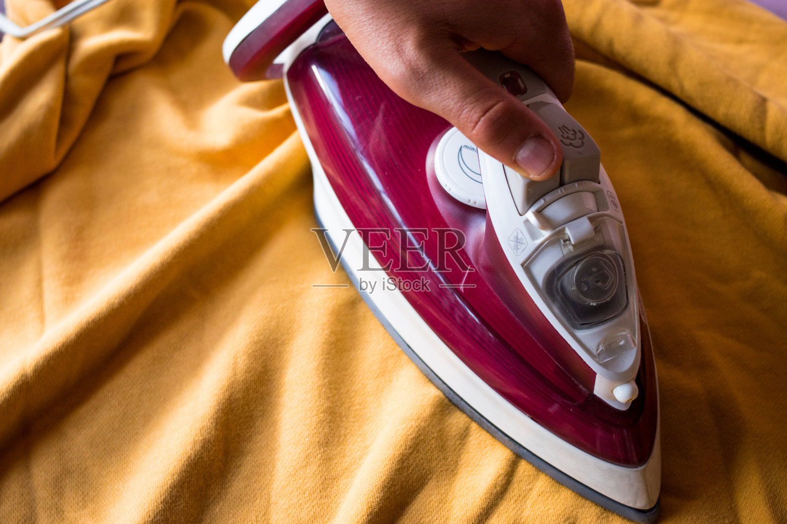 熨烫皱巴巴的黄衣服照片摄影图片