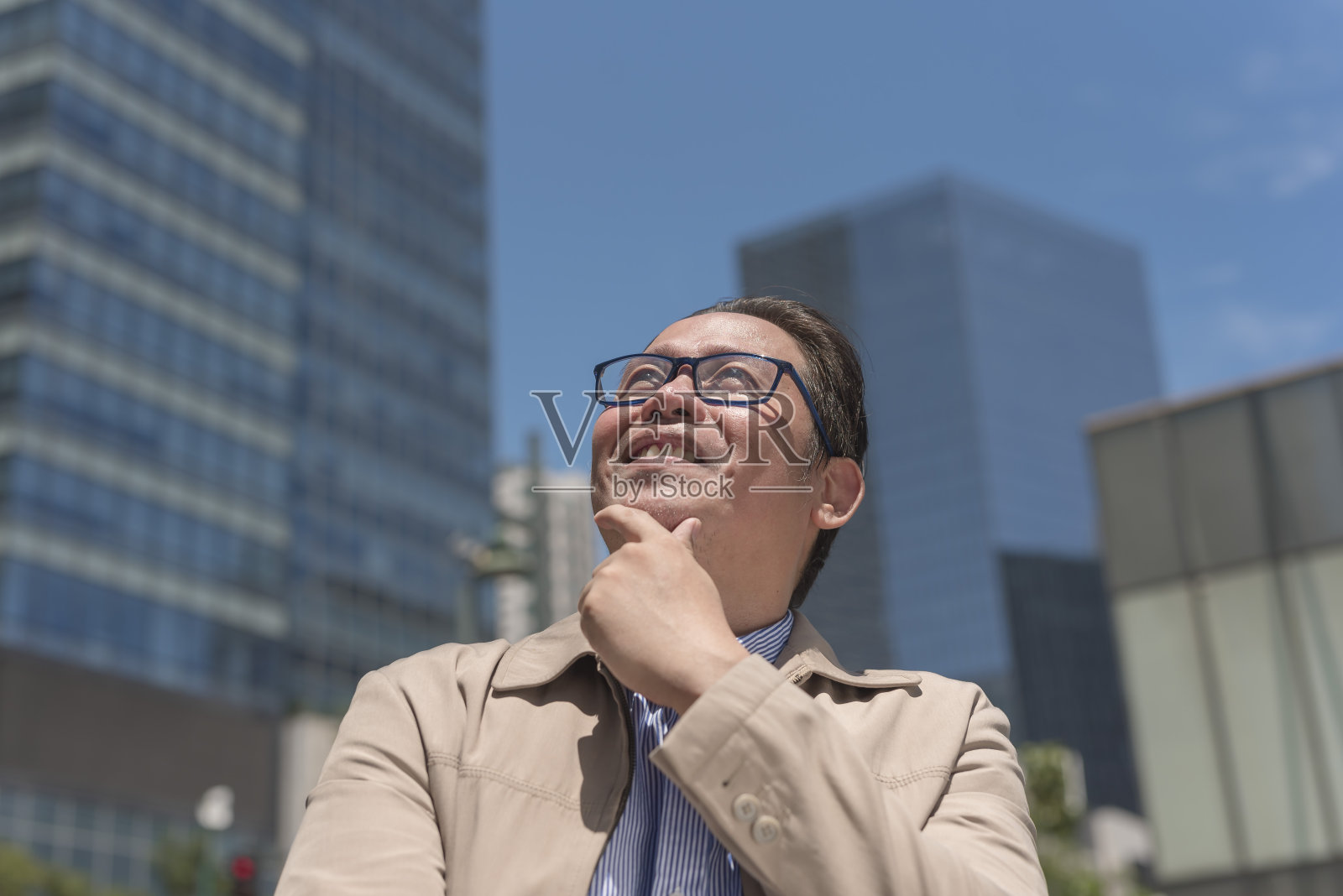 一个乐观的中年男性职业人士在城市里散步时抬头看着自己的成功。照片摄影图片