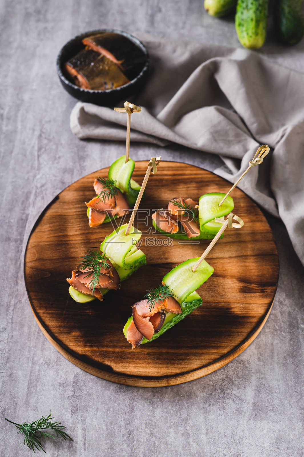 美味的黄瓜、红鱼和莳萝在桌子上的一块板上垂直观看照片摄影图片