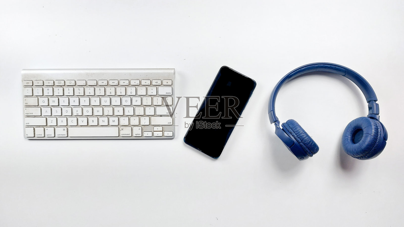 键盘，手机和耳机在白色背景。照片摄影图片