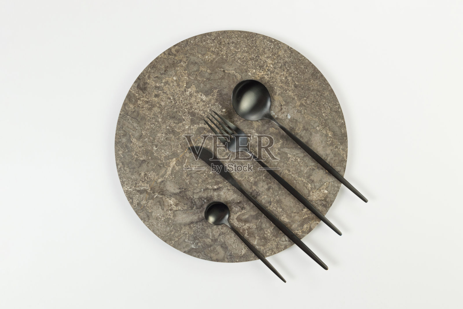 棕色大理石盘子的俯视图，白色背景上的黑色餐具。食物摆放，石盘。照片摄影图片