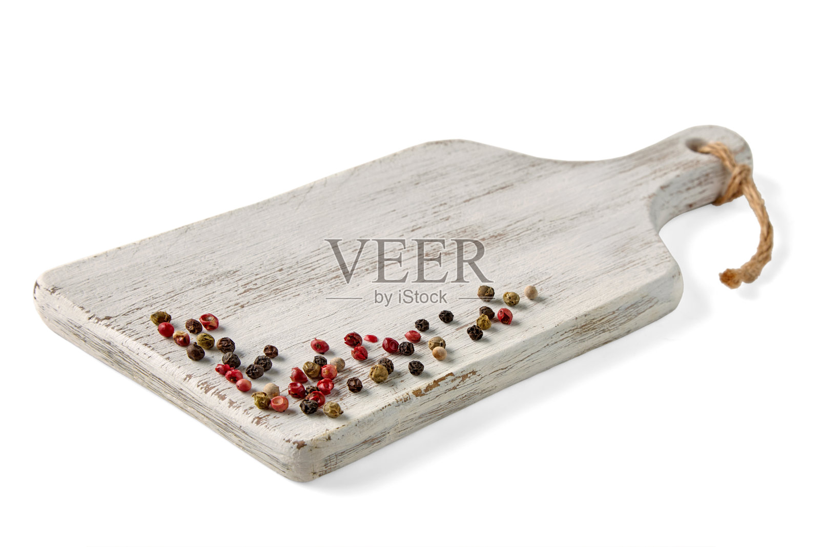 木制的白色油漆砧板，在白色的背景上点缀着五颜六色的胡椒照片摄影图片