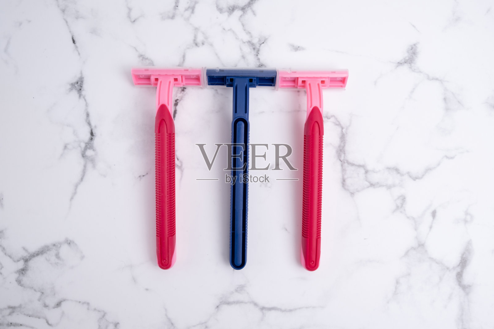 一次性塑料钢制刀片剃须刀，男女用剃须刀。皮肤和身体护理理念。脱毛。放文字的地方照片摄影图片