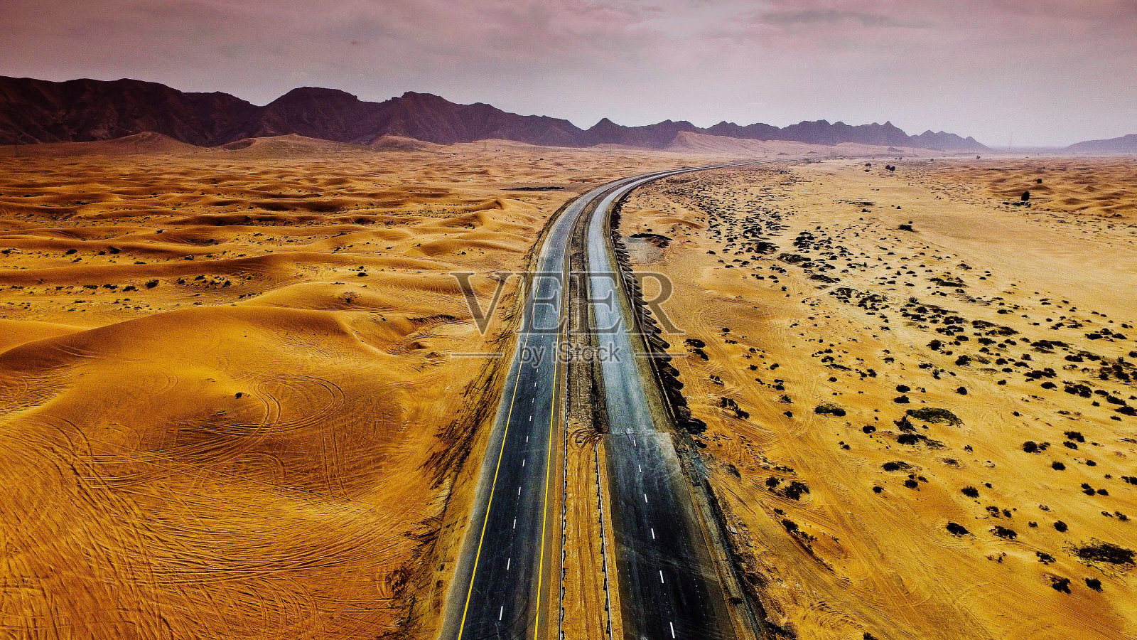 轮胎痕迹在景观对抗戏剧性的天空照片摄影图片