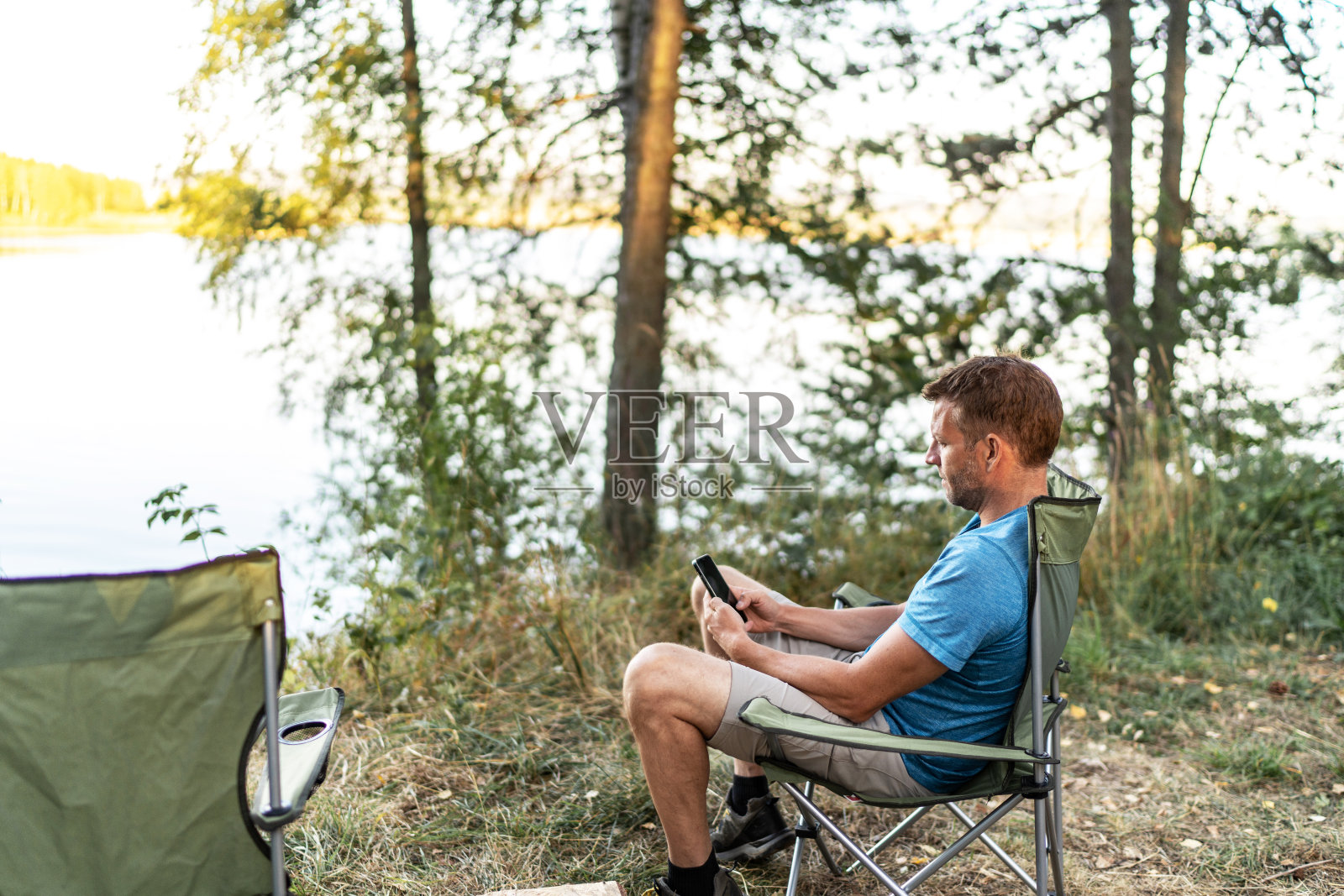 一个年轻人在森林露营时使用他的智能手机照片摄影图片